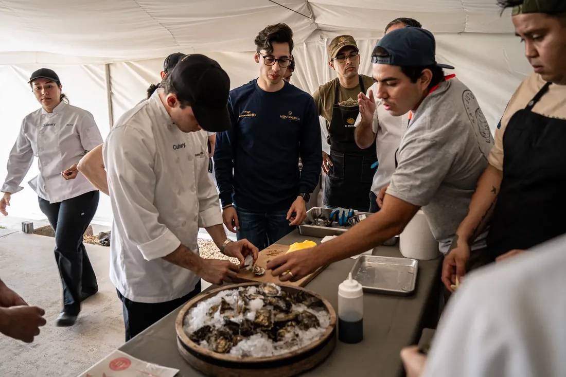 Chef demostrando el shucking de ostión a un grupo durante un taller